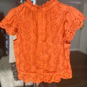 Orange eyelet blouse.